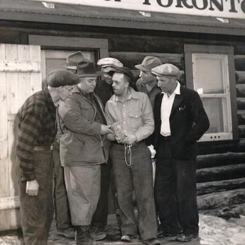 Group of men looking at gold sample outside Bank of Toronto, 1946 (Peter Schwerdt Collection)